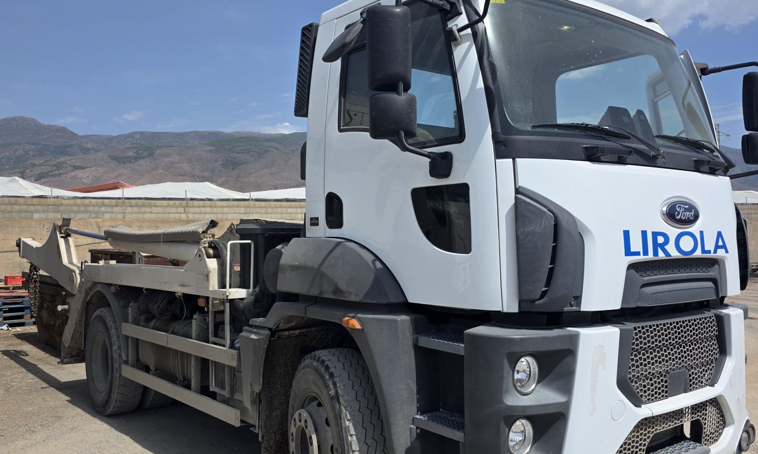 Camión de cadenas de Contenedores Lirola con un contenedor cargado