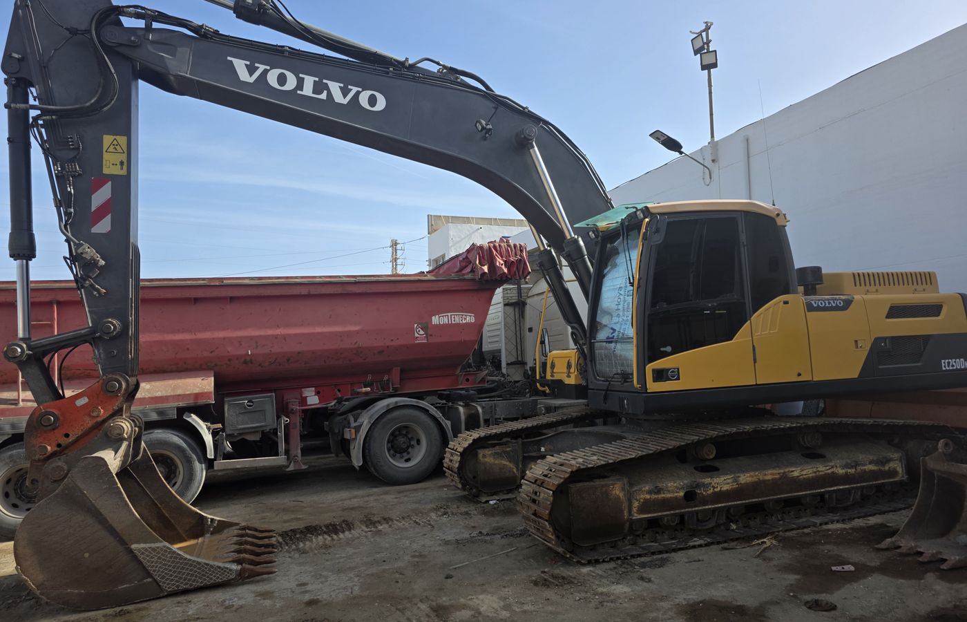 Excavadora de cadenas Volvo EC250D de Lirola junto a un camión bañera